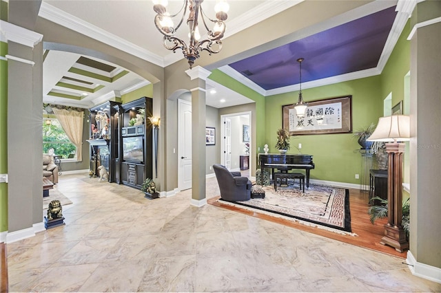 interior space featuring decorative columns, a notable chandelier, and ornamental molding