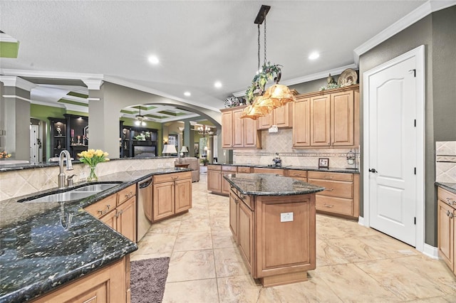 kitchen with sink, crown molding, hanging light fixtures, dark stone countertops, and a kitchen island