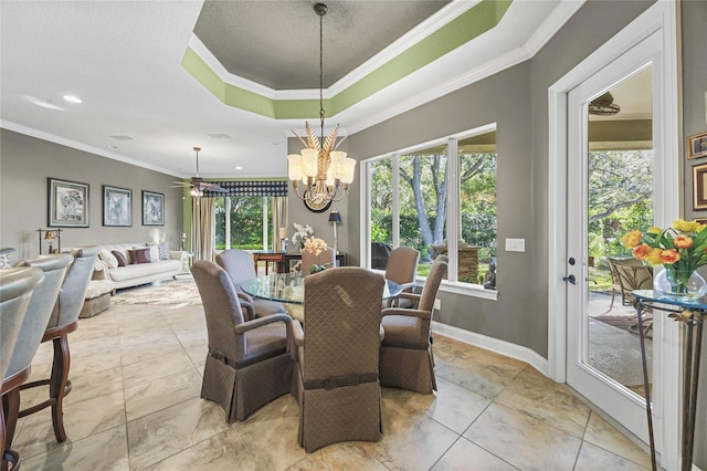 dining area featuring a tray ceiling, crown molding, and ceiling fan with notable chandelier