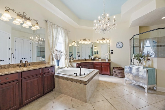 bathroom with tile patterned floors, a wealth of natural light, plus walk in shower, and vanity