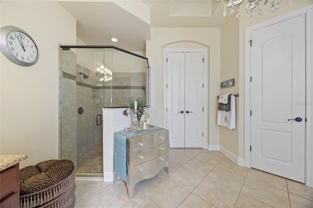 bathroom featuring tile patterned floors, vanity, an enclosed shower, and an inviting chandelier