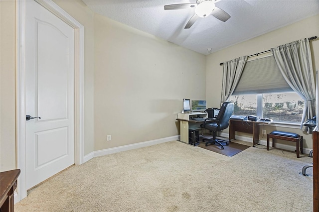 home office featuring carpet flooring, ceiling fan, and a textured ceiling