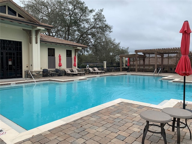 view of swimming pool featuring a patio area and a pergola