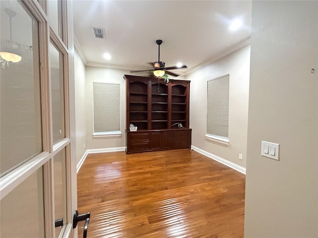 spare room featuring hardwood / wood-style floors, ceiling fan, and crown molding