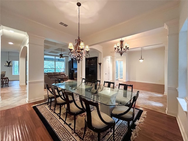 dining space featuring hardwood / wood-style flooring, beam ceiling, crown molding, and an inviting chandelier