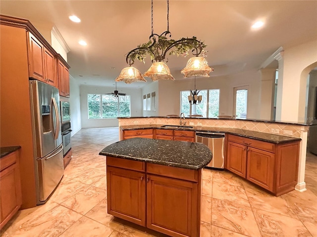 kitchen featuring a center island, sink, stainless steel appliances, dark stone counters, and decorative backsplash