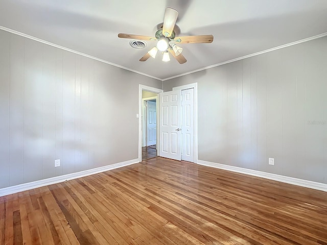 empty room featuring ornamental molding, hardwood / wood-style floors, and ceiling fan