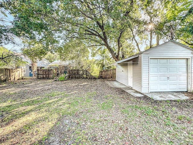 view of yard with a garage and an outbuilding