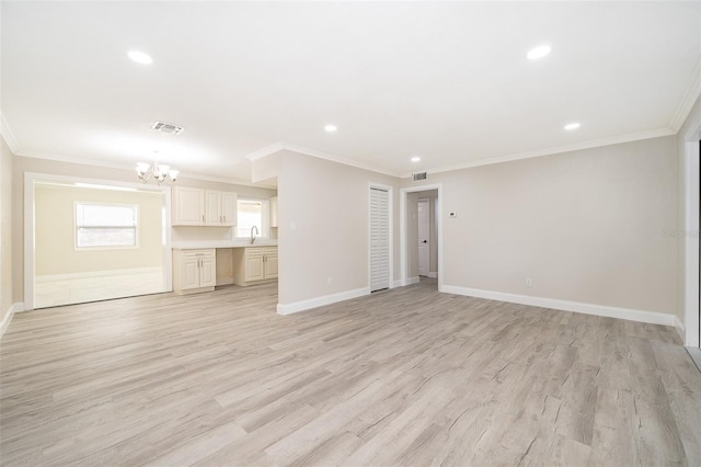 unfurnished living room featuring light hardwood / wood-style floors, ornamental molding, and an inviting chandelier