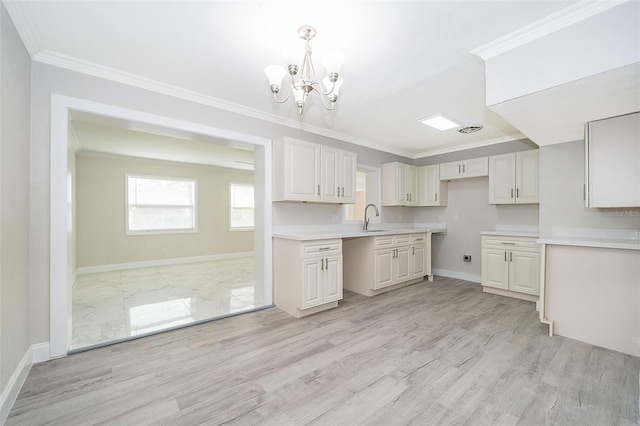 kitchen with hanging light fixtures, an inviting chandelier, light hardwood / wood-style flooring, crown molding, and sink