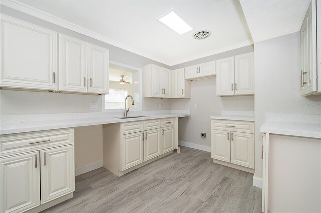 3703 Wade Rd, Orlando, FL 32808 - kitchen with a sink, light wood finished floors, ornamental molding, baseboards, and light countertops