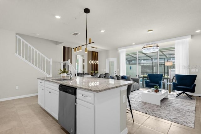 kitchen featuring white cabinetry, dishwasher, pendant lighting, and a kitchen island with sink