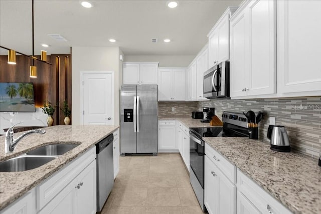 kitchen featuring sink, white cabinetry, light stone counters, and stainless steel appliances