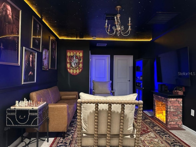 carpeted cinema room featuring a chandelier