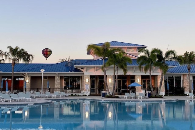 pool at dusk with a patio area