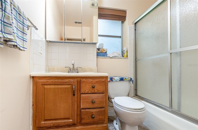 full bathroom with combined bath / shower with glass door, vanity, tasteful backsplash, and toilet