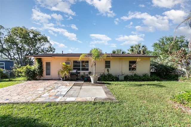 rear view of house featuring a patio area and a yard