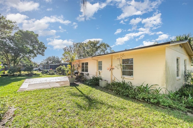 back of property featuring a patio area, a yard, and cooling unit