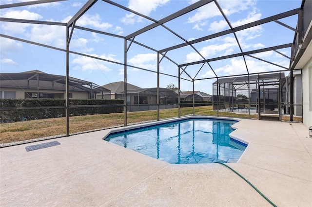 view of swimming pool with a lanai, a patio, and a lawn