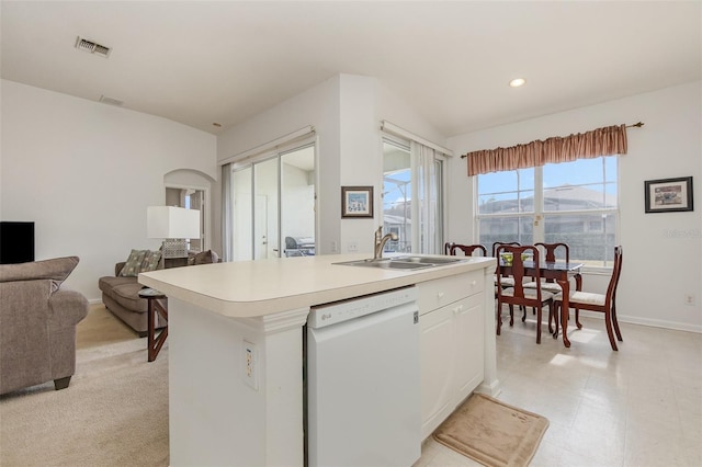 kitchen featuring white dishwasher, sink, a center island with sink, and white cabinets