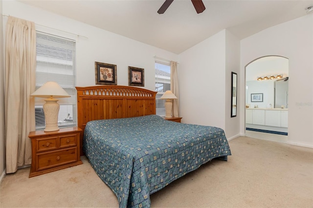 carpeted bedroom with ceiling fan, lofted ceiling, and connected bathroom