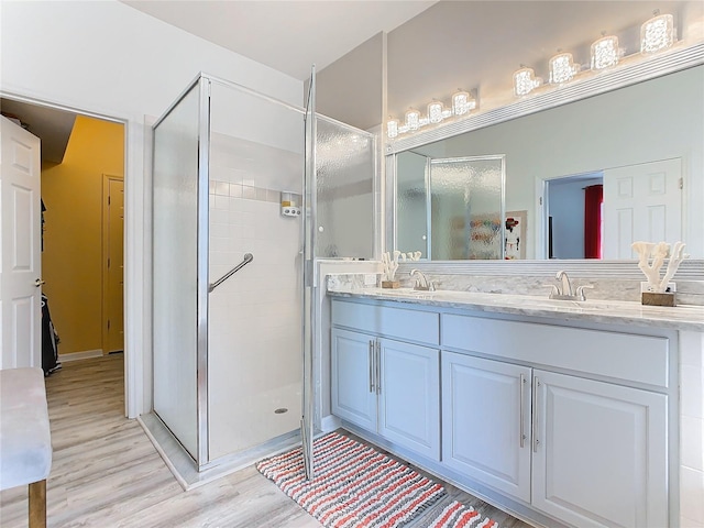 bathroom featuring a shower with door, vanity, and hardwood / wood-style flooring