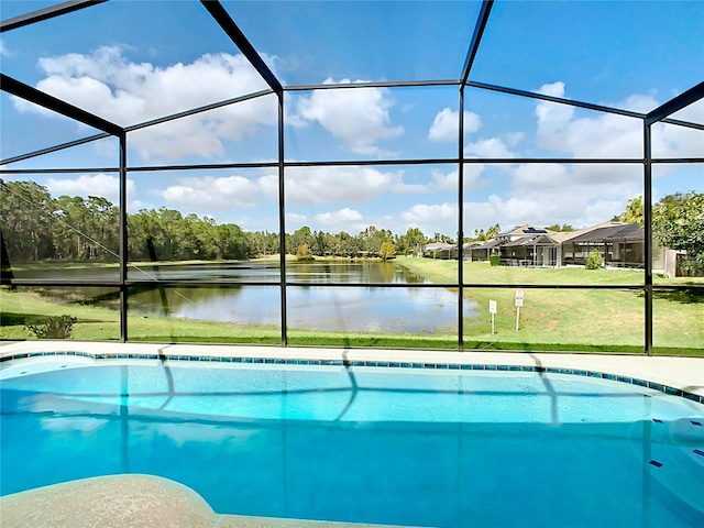 view of swimming pool with a lawn, glass enclosure, and a water view