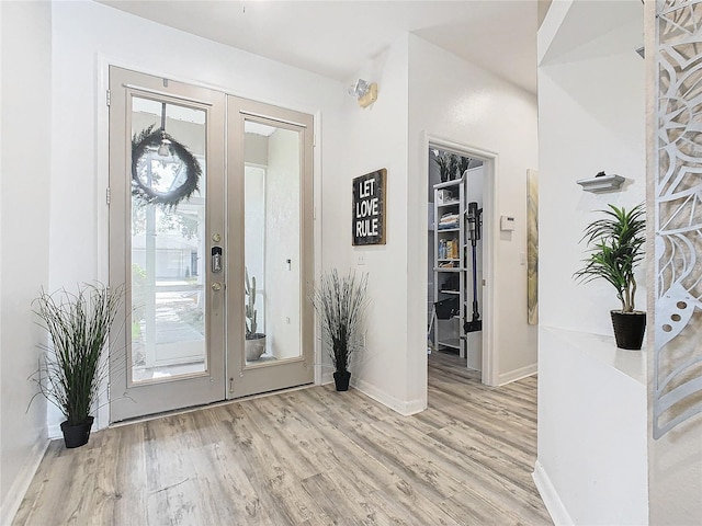 entrance foyer with french doors, baseboards, and wood finished floors