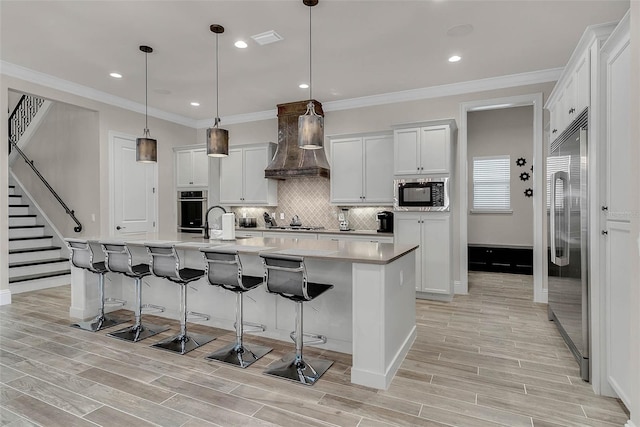 kitchen with white cabinetry, a kitchen island with sink, and appliances with stainless steel finishes