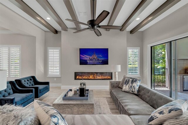 living room with beamed ceiling, ceiling fan, and light hardwood / wood-style floors