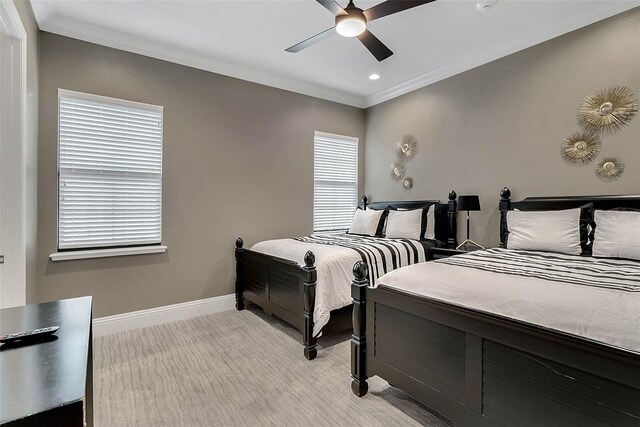 carpeted bedroom featuring ceiling fan and crown molding