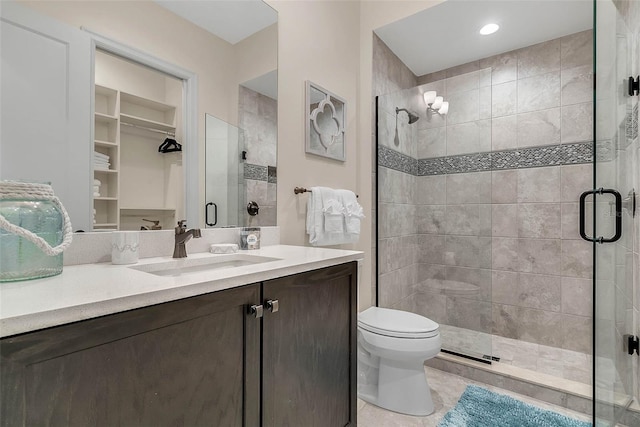 bathroom with tile patterned floors, toilet, vanity, and walk in shower