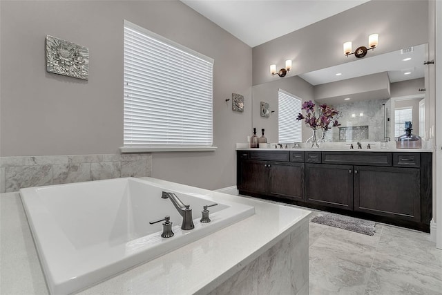 bathroom with vanity and a relaxing tiled tub