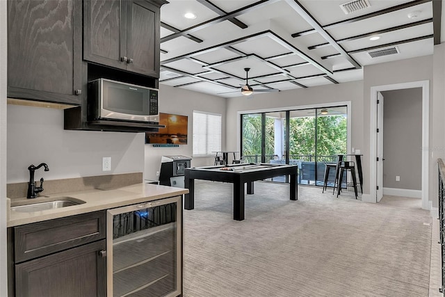 playroom with coffered ceiling, light colored carpet, ceiling fan, sink, and wine cooler