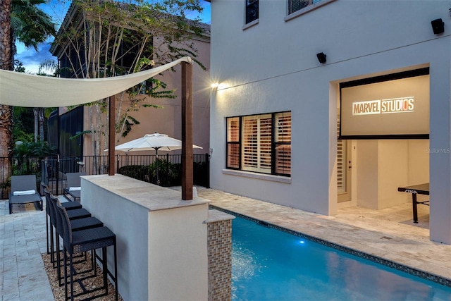 view of swimming pool featuring a patio area and exterior bar