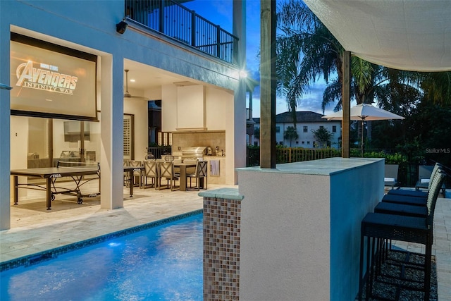 view of pool featuring a patio area, exterior bar, and an outdoor kitchen