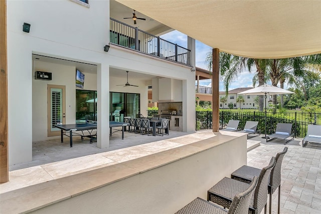 view of patio featuring an outdoor kitchen, a balcony, and ceiling fan