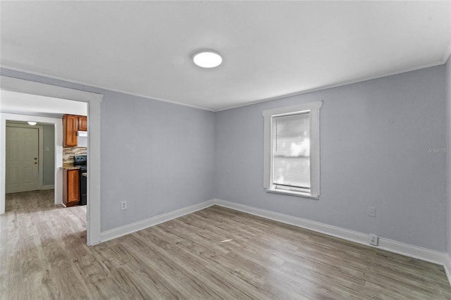 empty room featuring ornamental molding and light hardwood / wood-style floors