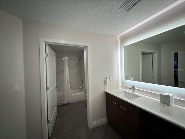 bathroom with vanity, wood-type flooring, a textured ceiling, and shower / tub combo with curtain