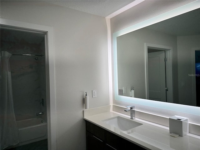 bathroom featuring shower / bath combo, vanity, and a textured ceiling