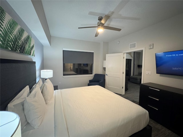 bedroom featuring ceiling fan, dark wood-type flooring, and a textured ceiling