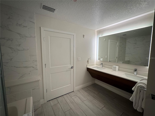 bathroom with vanity, wood-type flooring, and a textured ceiling