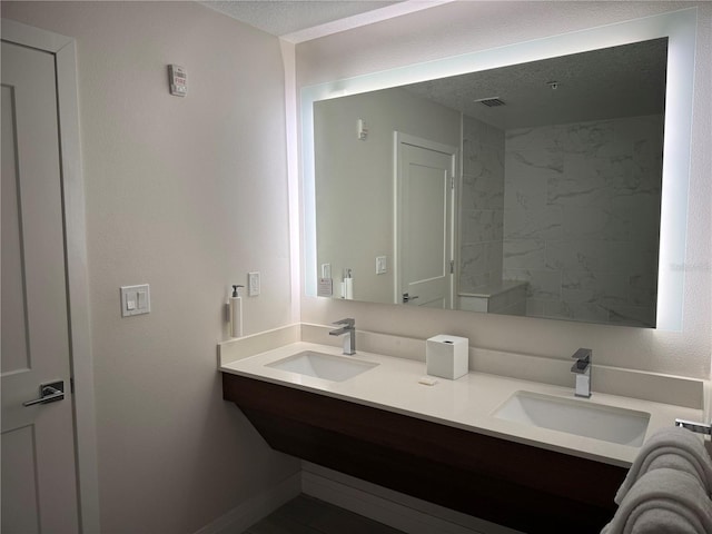 bathroom featuring a textured ceiling and vanity