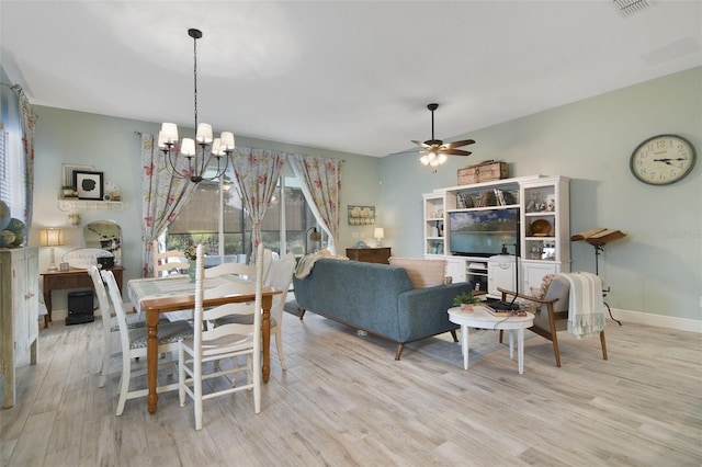 dining space with ceiling fan with notable chandelier and light wood-type flooring