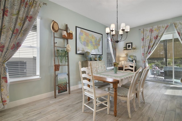 dining area featuring a notable chandelier and light wood-type flooring