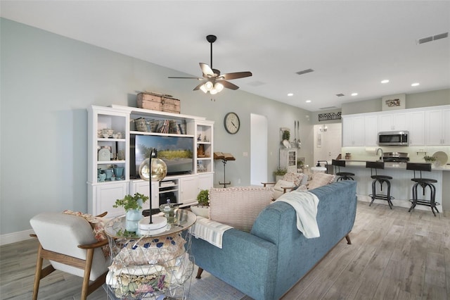 living room with light hardwood / wood-style flooring and ceiling fan