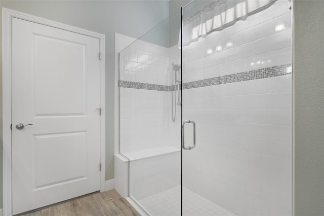 bathroom featuring wood-type flooring and an enclosed shower