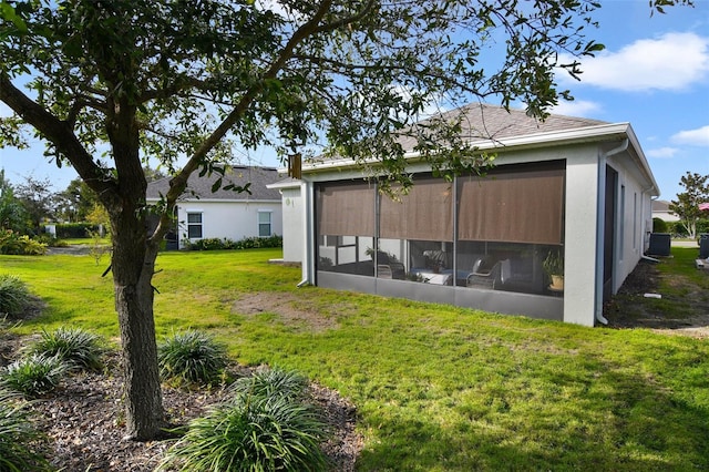 rear view of property featuring a lawn and a sunroom