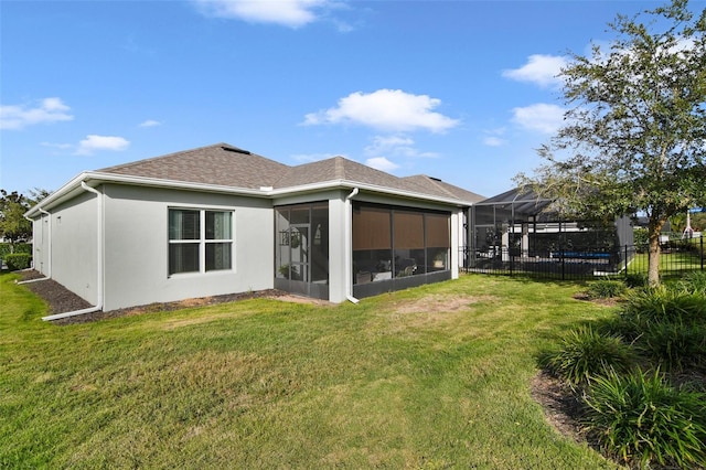 back of property featuring a sunroom, a pool, a yard, and a lanai