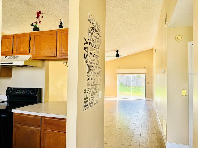 kitchen featuring a textured ceiling, lofted ceiling, electric range, and light wood-type flooring